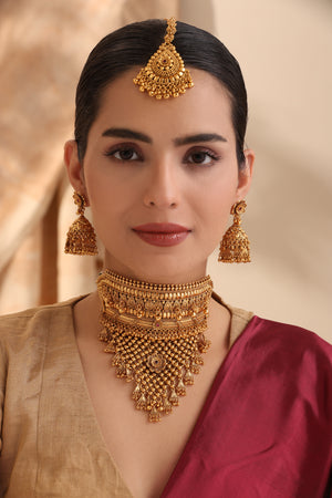 Rajasi Antique Gold Choker Set with jhumka earrings and maang tikka on model – Indian bridal jewelry