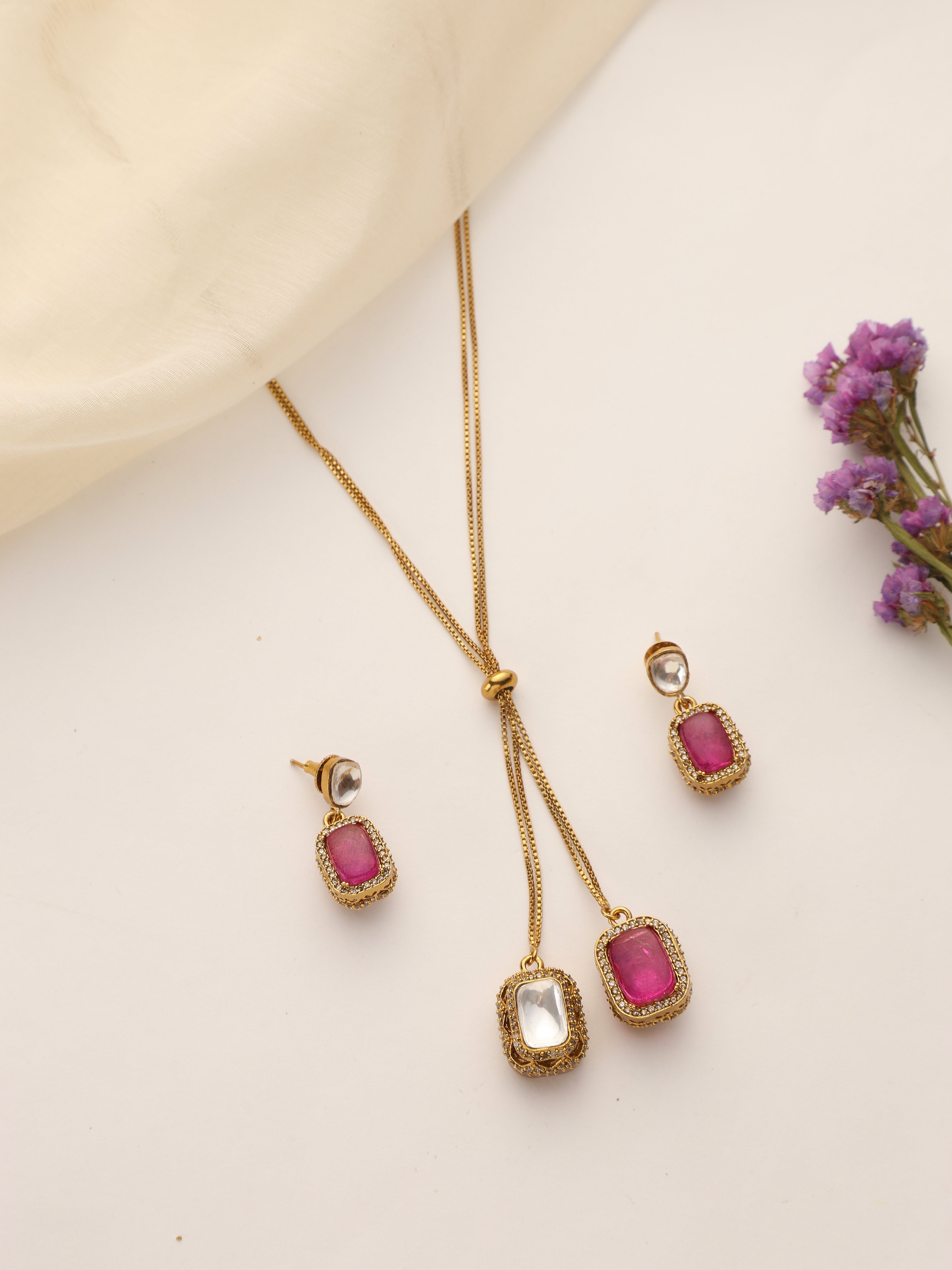Flatlay of Dual Stone Ruby & Polki Pendant Set with Earrings – Gold Plated