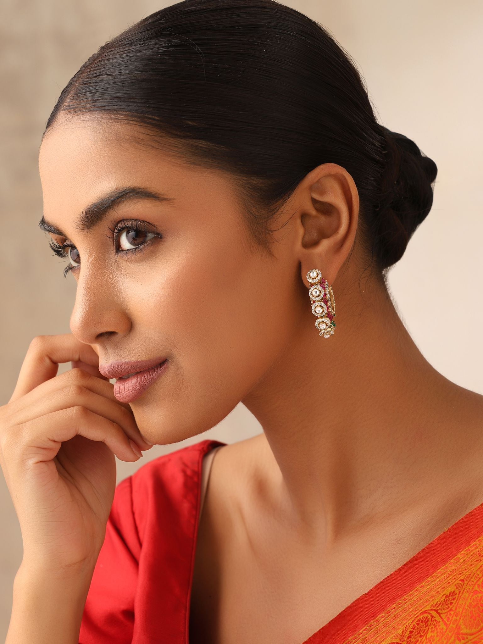 Traditional gold-plated kundan hoops with pearls, styled with saree.