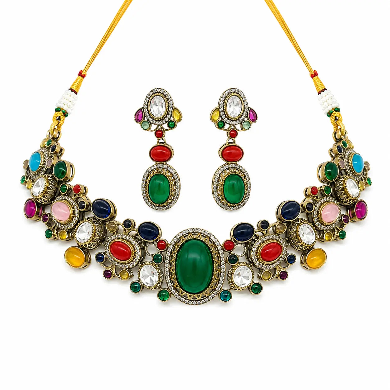 An ornate Indian style jewelry set featuring a statement necklace and matching drop earrings. The set is decorated with multiple colorful stones including green, red, blue, pink, yellow, and white, set in gold-toned metal with clear rhinestone accents.