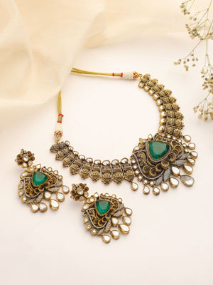 Ornate necklace with green stones on a light background