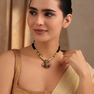 Model wearing black-thread necklace with oval stone pendant