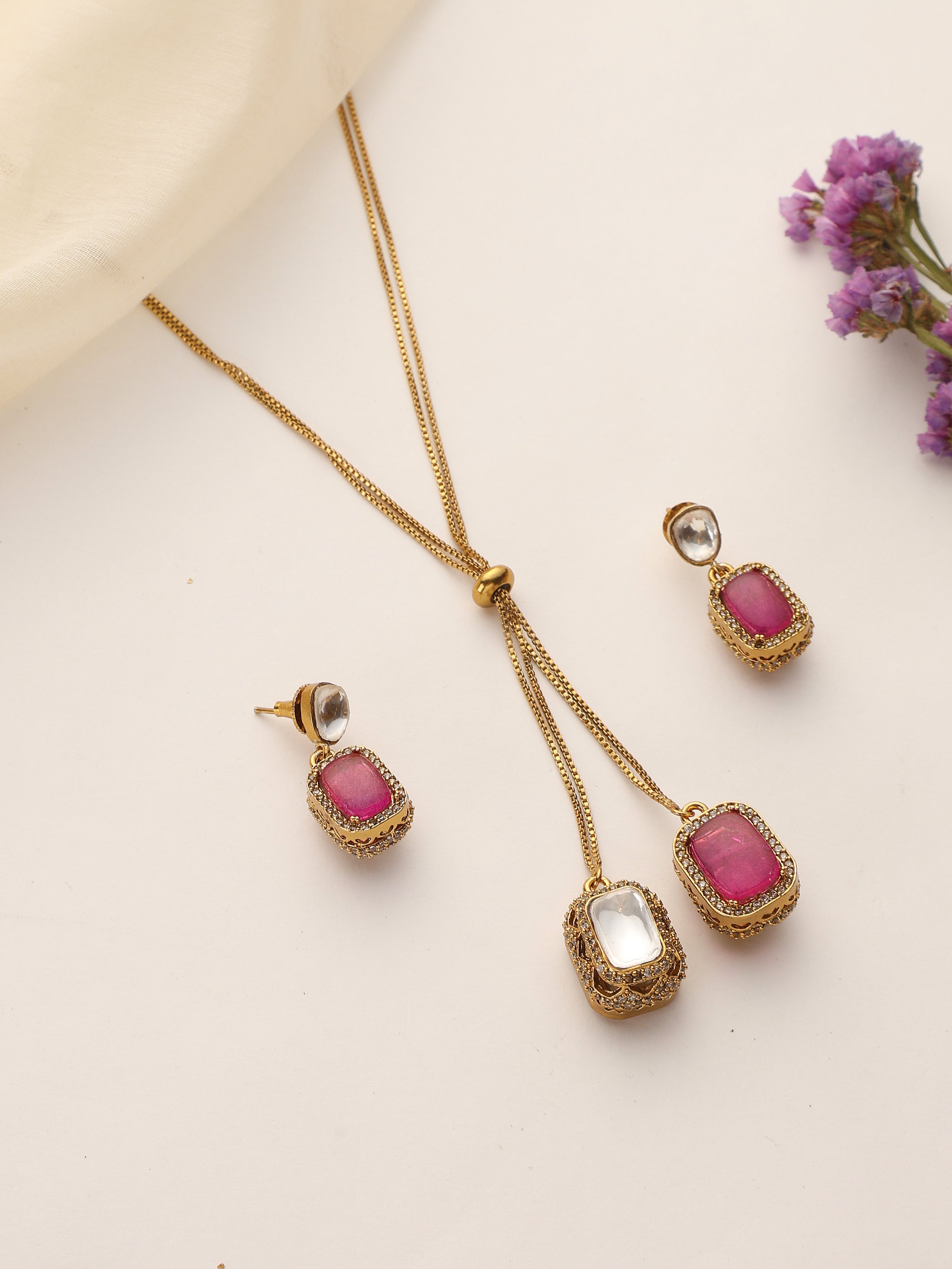 flatlay of Dual Stone Ruby & Polki Pendant Set with Earrings – Gold Plated