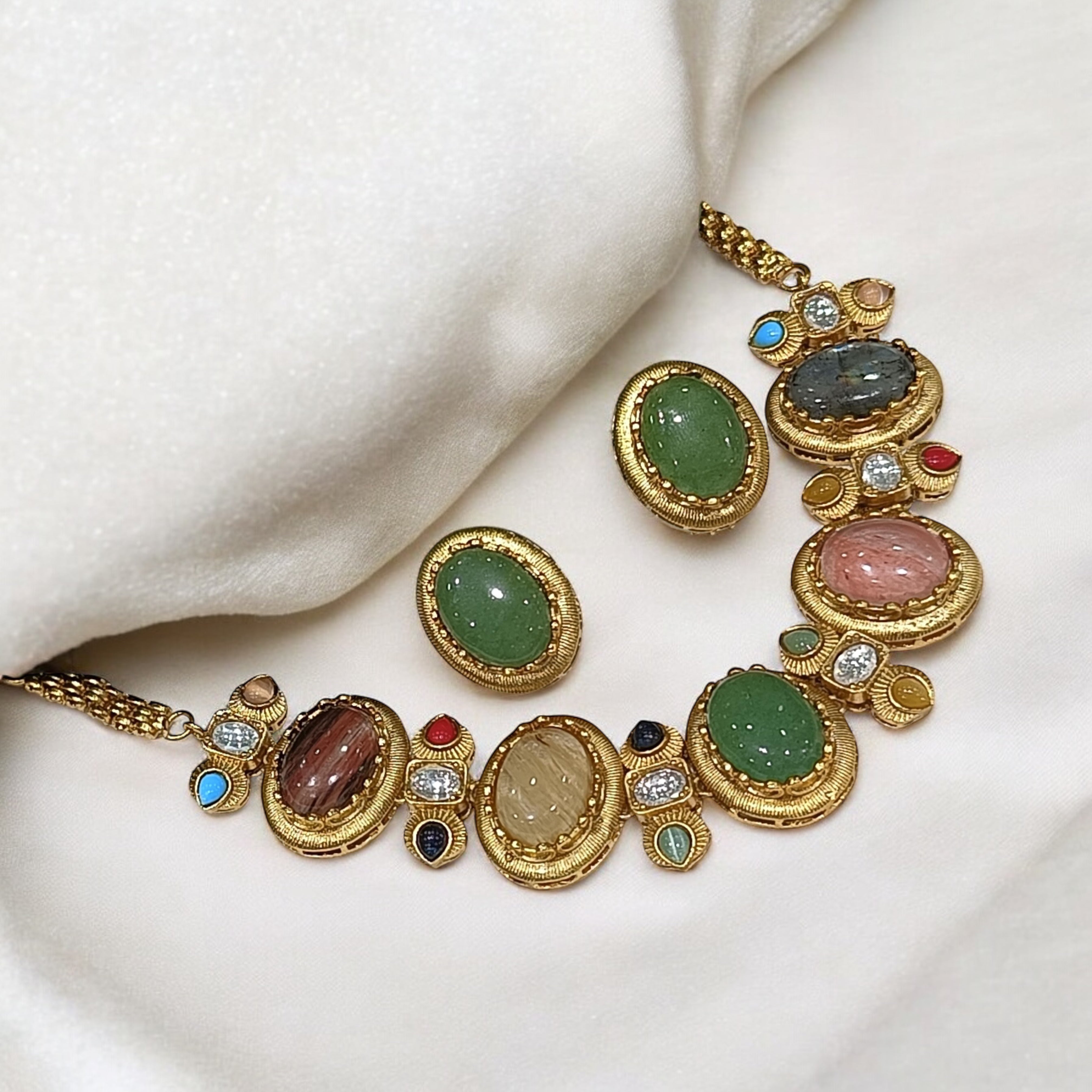 Antique gold-plated necklace with bold oval cabochon stones in green, pink, brown, and blue with matching stud earrings.