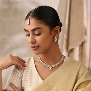Woman wearing traditional jewelry including a necklace, earrings, and a headband.