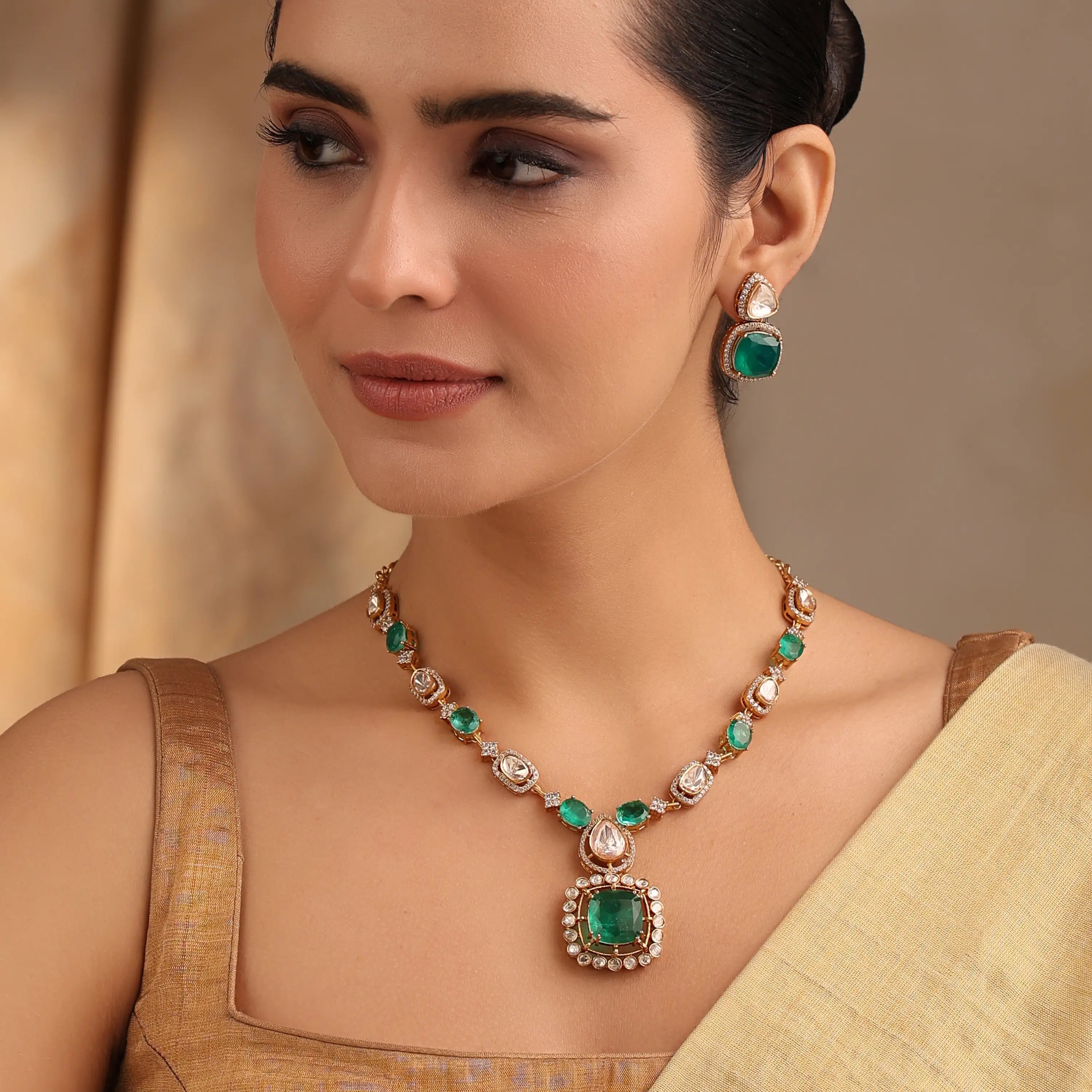 Close-up of emerald and polki stone necklace with matching earrings