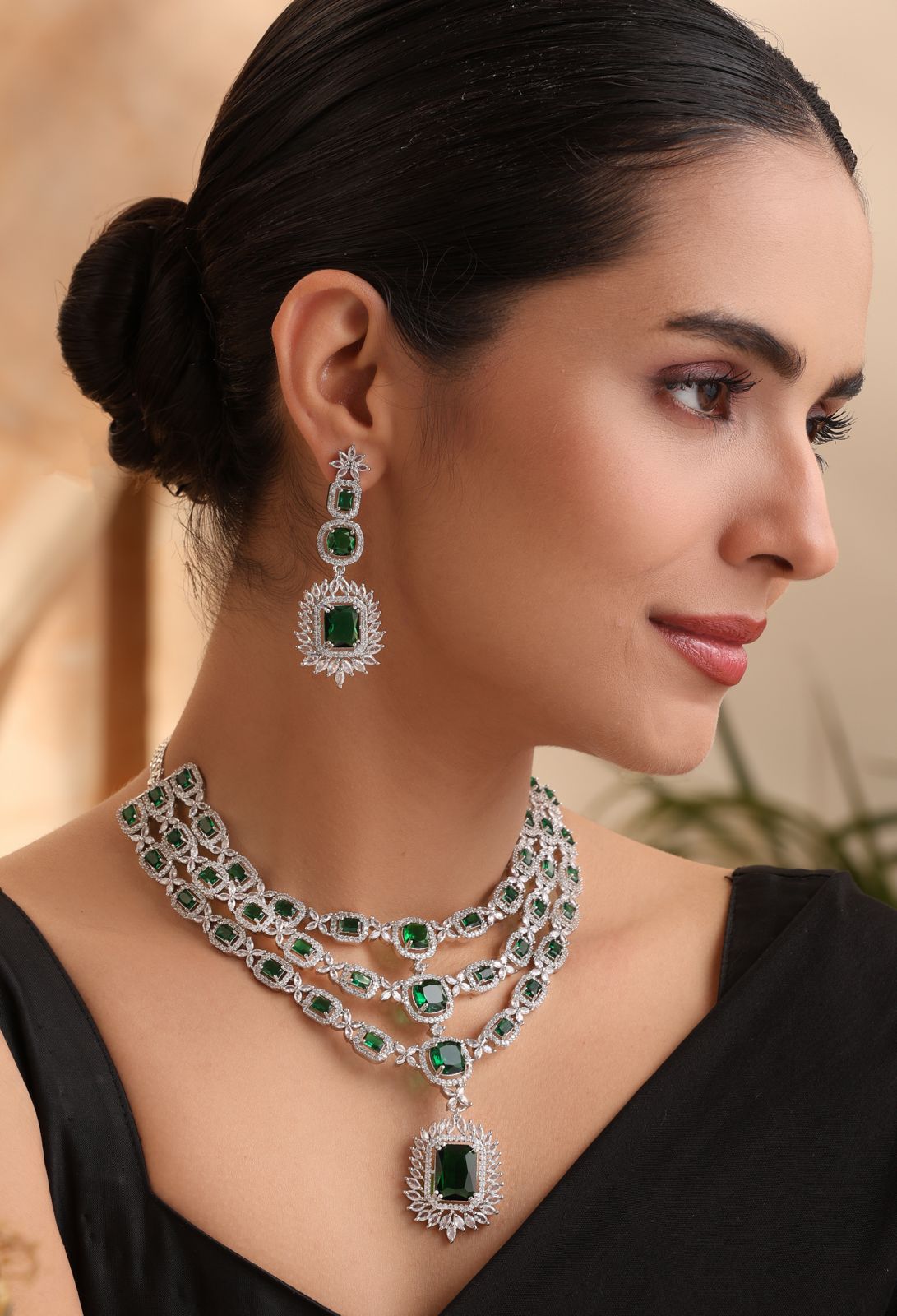emerald-grace-model-front — “Emerald Grace triple-layer emerald CZ necklace with matching earrings on model, silver finish.”