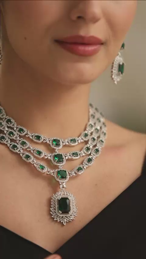 emerald-grace-model-front — “Emerald Grace triple-layer emerald CZ necklace with matching earrings on model, silver finish.”