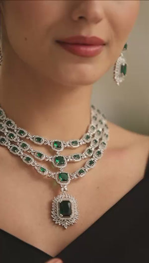 emerald-grace-model-front — “Emerald Grace triple-layer emerald CZ necklace with matching earrings on model, silver finish.”